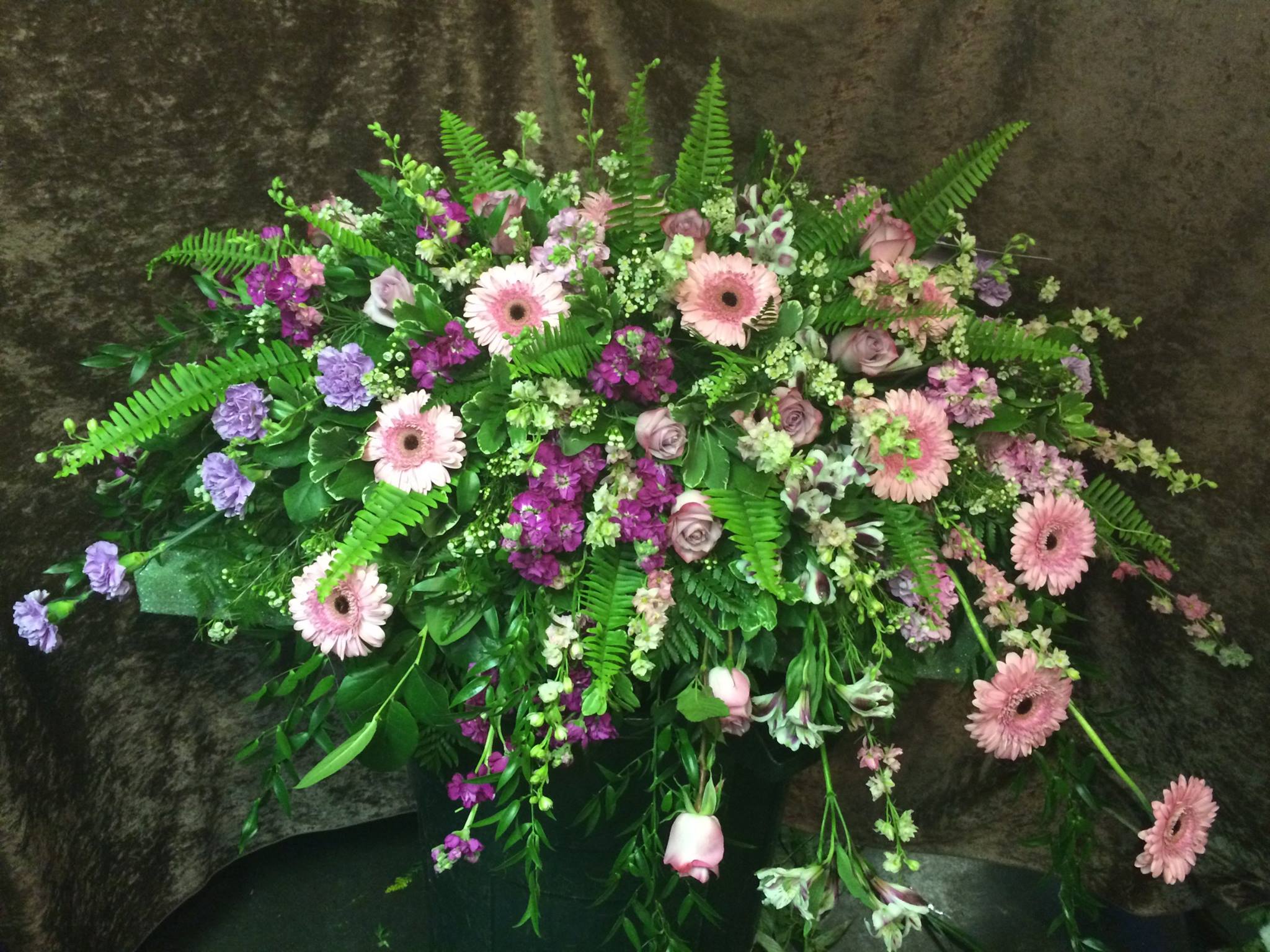 Soft pink gerber daisys designed in a more modern style along with a mixture of soft pastel tones and assorted greens. Prices start at $295 for a piece designed like this. Some of the florals shown in this pic are seasonal.